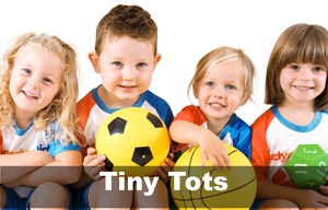 Young children holding sports balls and toys.